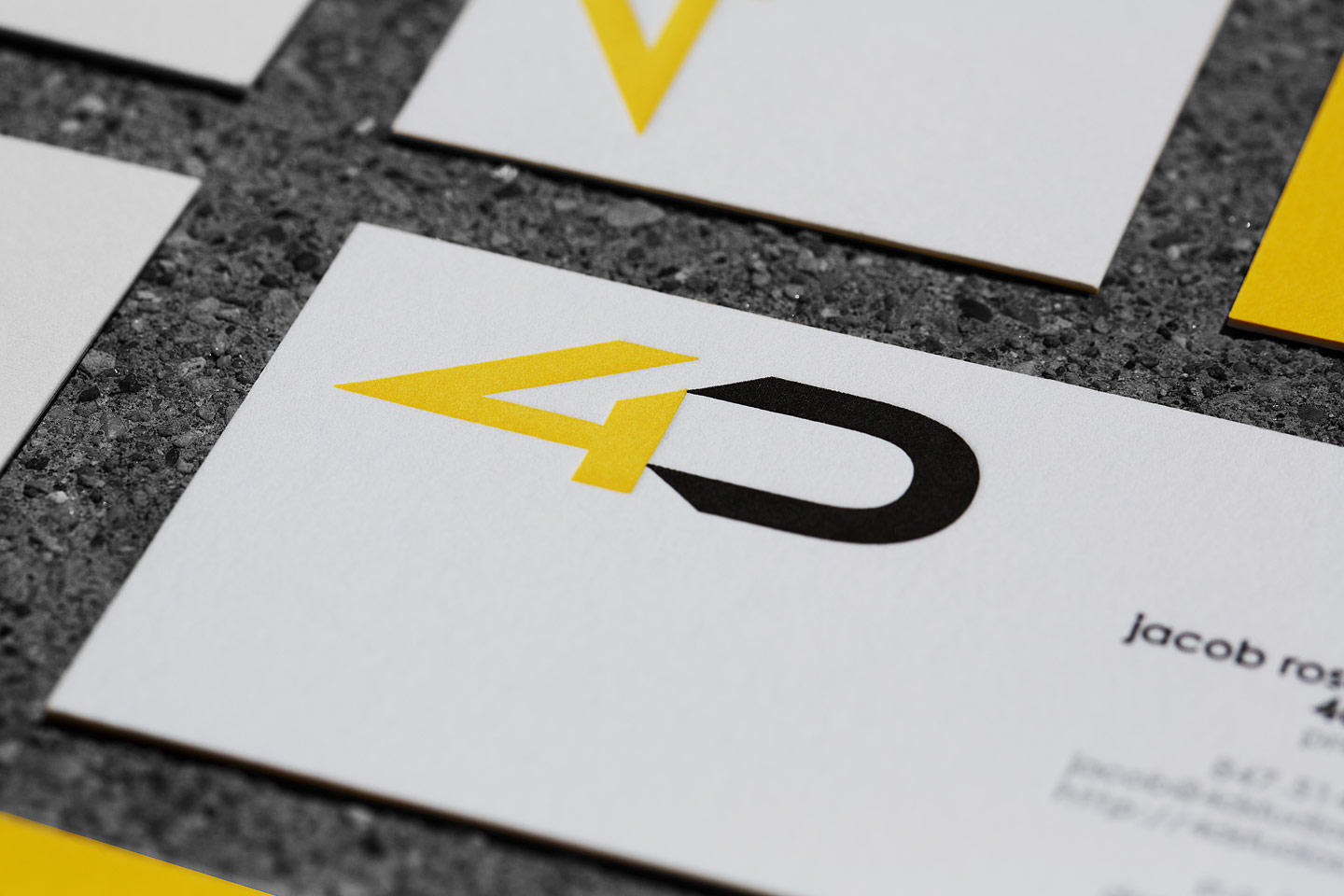 a grouping of 4D letterpress business cards, featuring some right side up, with others upside down