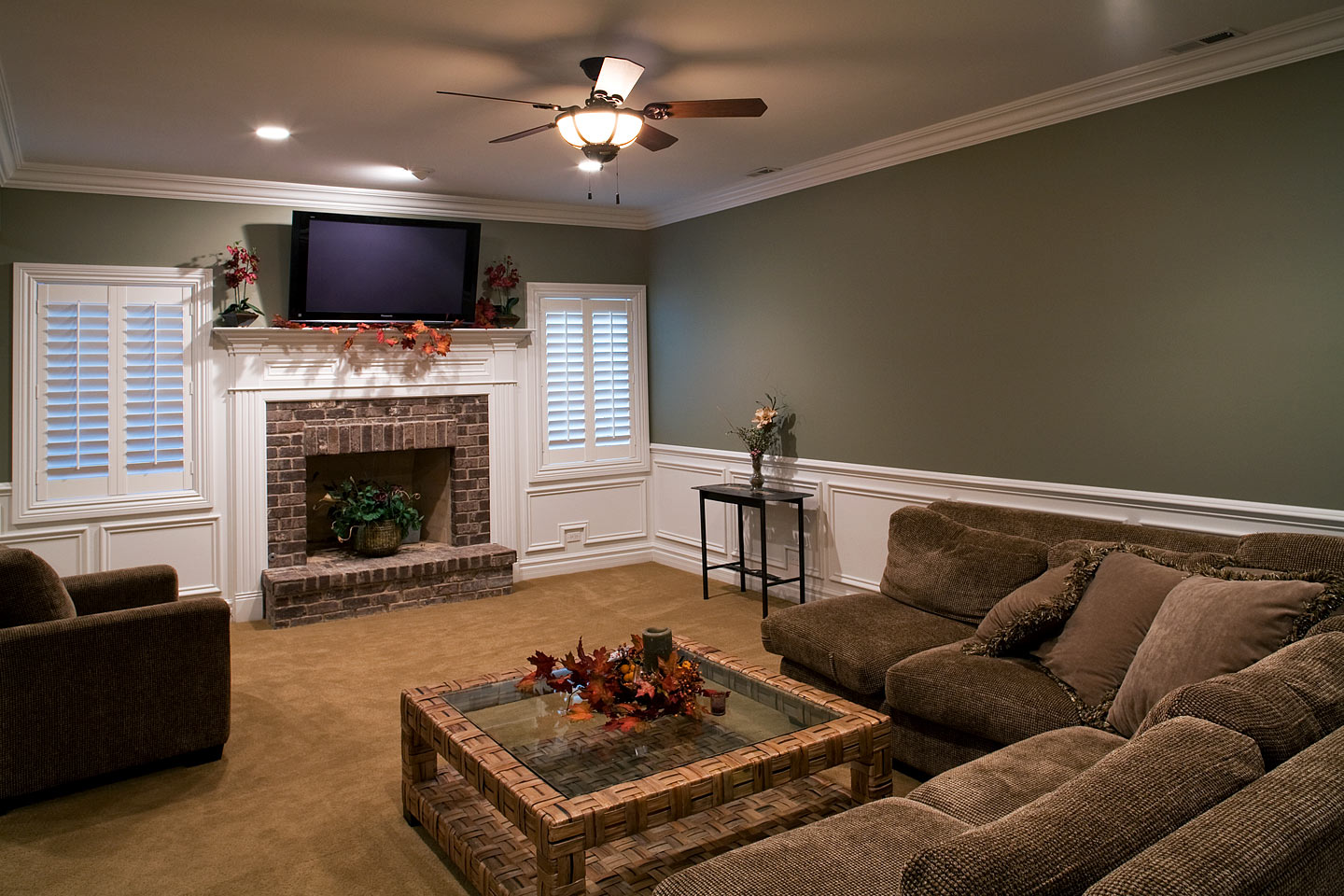 a nice basement seating area featuring a fireplace surrounded by comfortable couches, photographed by Jacob Rosenfeld