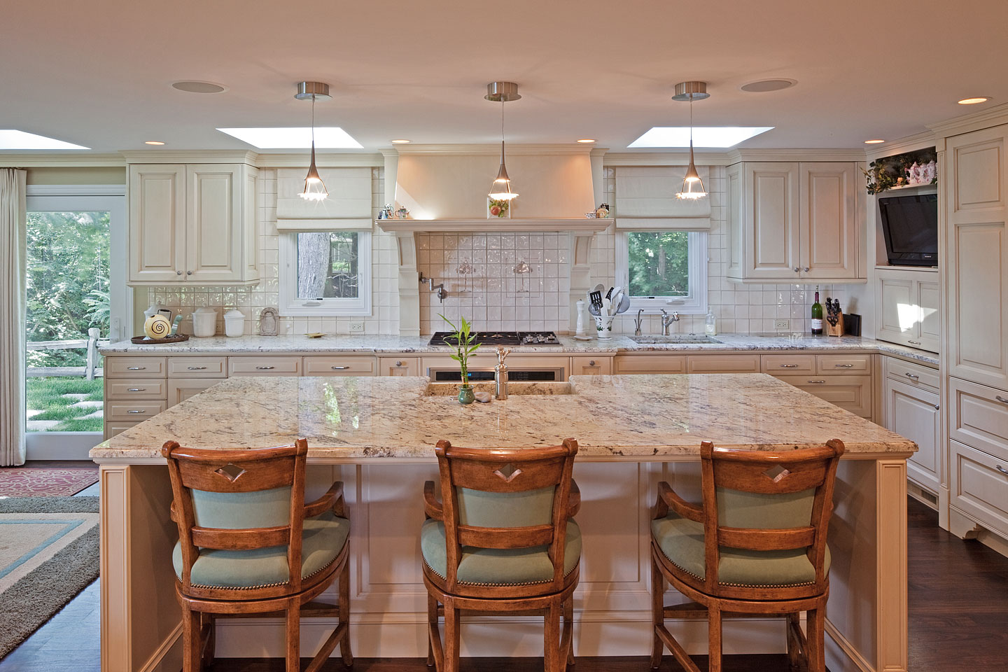 a panorama of a large modern kitchen, featuring a huge granite topped island and lots of cabinets, photographed by Jacob Rosenfeld